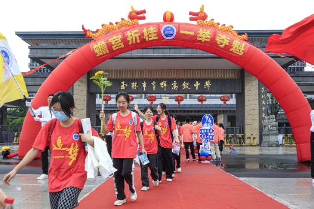 玉林市育輝高級中學紅毯鋪地，紅聯(lián)掛樓，為勇士出征高考助威祝福。在一片助威聲中，育園學子目光如炬，步伐堅定，意氣風發(fā)地邁過狀元門，斗志昂揚地出征高考。（陳穎強  周家名）.png