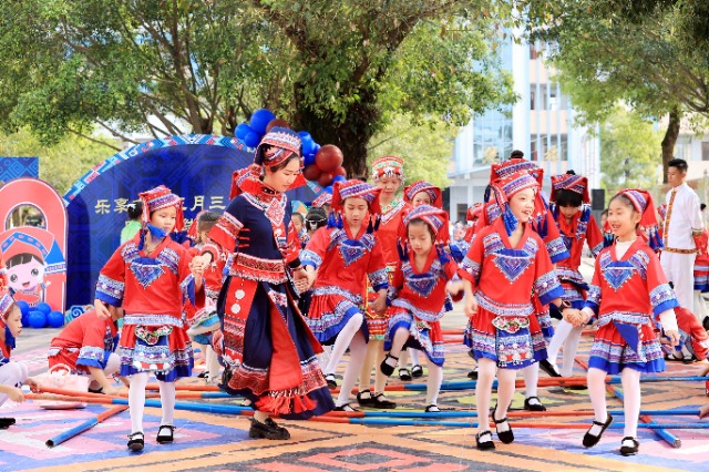 圖4：4月9日，在廣西柳州市融安縣實(shí)驗(yàn)小學(xué)校園，一名老師帶著學(xué)生跳竹竿舞。（譚凱興 攝）.JPG